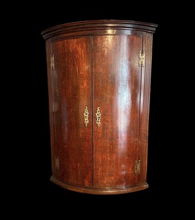 A fine Welsh oak hanging corner cupboard from the 18th century, with beautifully figured oak, elegant proportions, a shaped cornice and a rich original patina.