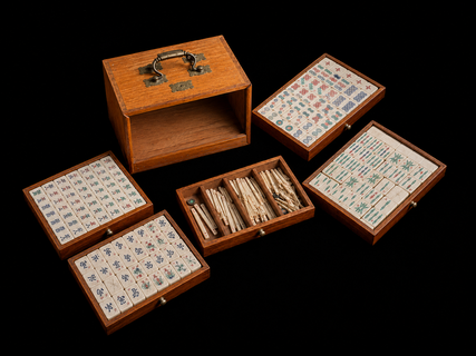 An early 20th century Chinese Mahjong set housed in its original hardwood carrying case, complete with hand engraved bone and bamboo tiles, five removable drawers and original scoring sticks.